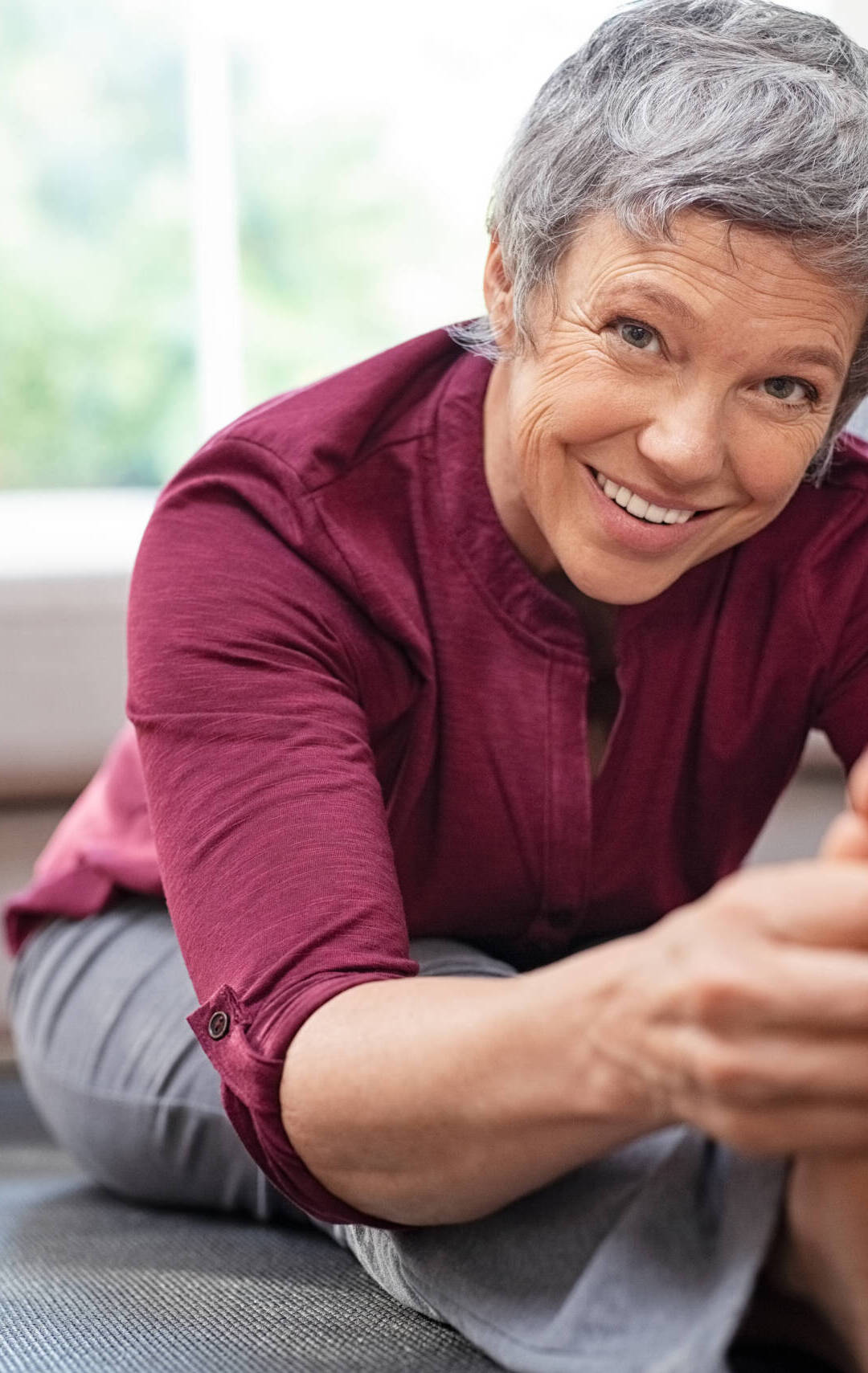 Closeup,Of,Senior,Woman,Stretching,To,Touch,Toes,While,Sitting